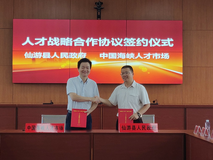 中国海峡人才市场副总经理杨石(左)与仙游县副县长郑文炉代表各方签订